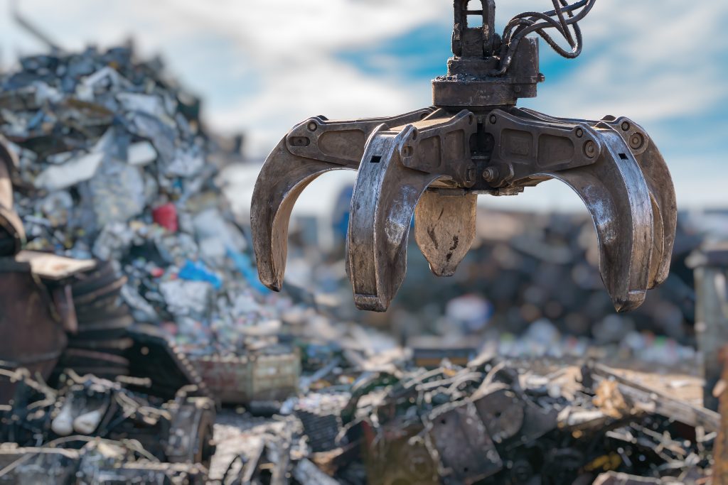 close up view on mechanical arm claw of crane at landfill.